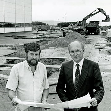 Two men holding drawing plans for new facility to represent Trelleborgs international expansion