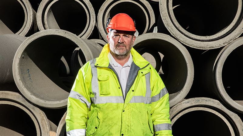 Julian standing in front of concrete pipes
