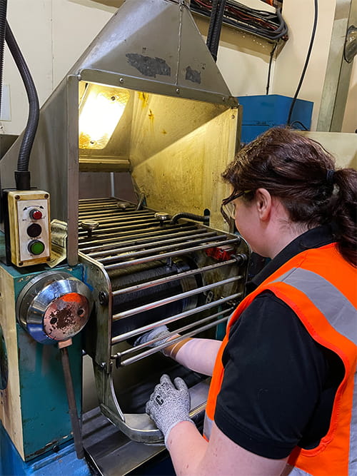 Beth Jordan operating a rubber processing machine