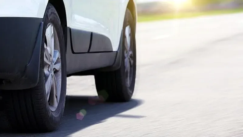 Close-up of the wheels of a car driving on the road
