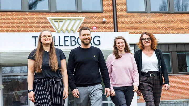 4 smiling people walking away from the Trelleborg HQ