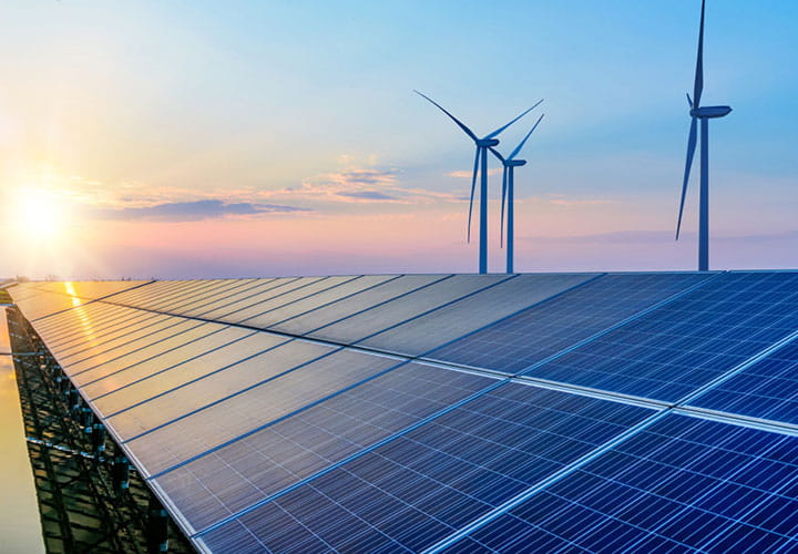 Sustainable energy production with wind turbines and solar panels in sunset