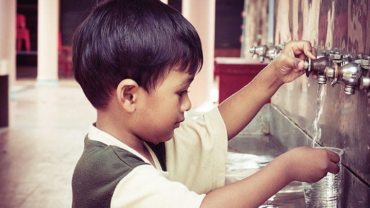 Child getting water from tap