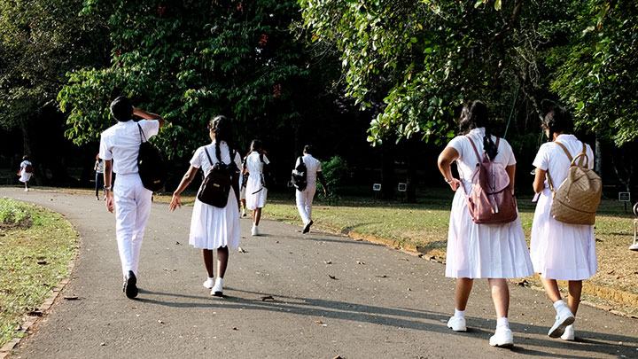 School students in Sri Lanka walking and wearing white uniforms