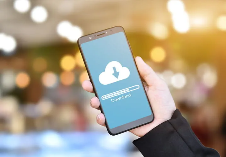 Hand holding a smartphone with a cloud download icon and progress bar on the screen