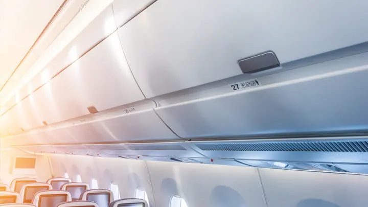 Aircraft cabin interior with overhead luggage compartments and passenger seats