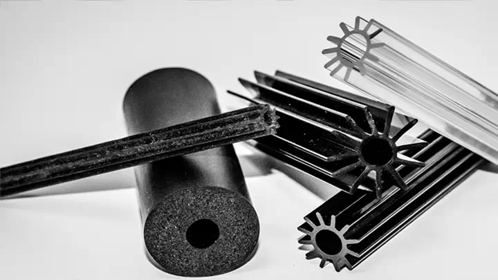 Assortment of black and transparent rubber profiles and dampers arranged on a white surface