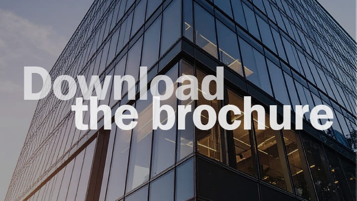 Modern glass office building facade with large reflective windows and overlay text reading “Download the brochure”