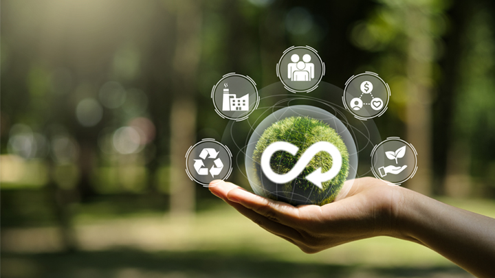 Hand holding a green sphere with an infinity symbol, representing sustainable circular sealing profiles with recycling and efficiency icons in a natural setting