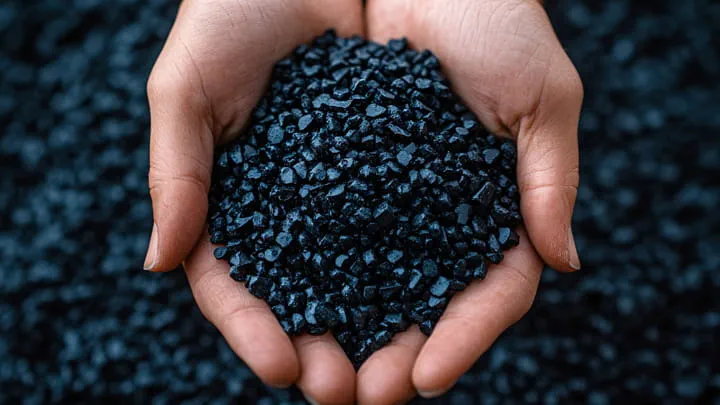 Hände, die schwarze TPE-Granulate halten, die für die Profilextrusion verwendet werden