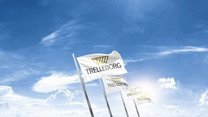 Les drapeaux de Trelleborg flottant dans un ciel bleu, représentant le siège social de l'entreprise
