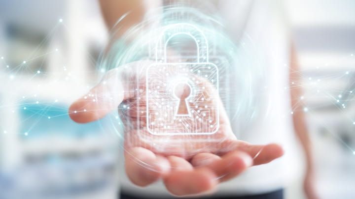 Main tenant une icône lumineuse représentant un cadenas numérique symbolisant la sécurité et la protection des données