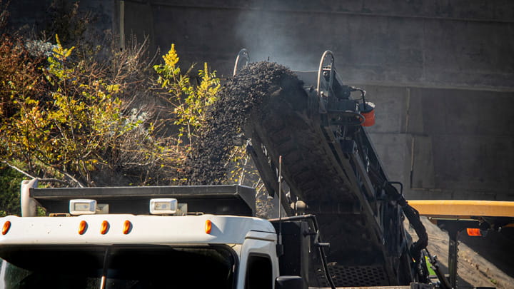 Carry Rock specialized Chevron conveyor belt unloading highly abrasive materials into a truck in a heavy‑duty industrial environment