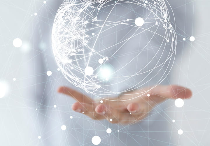 Hand holding a glowing digital sphere with interconnected lines and nodes