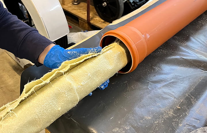 Fiberglass pipe liner being inserted into a drainage pipe during trenchless repair