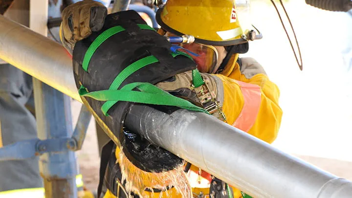 A man fixing a pipe that conveys hazardous materials