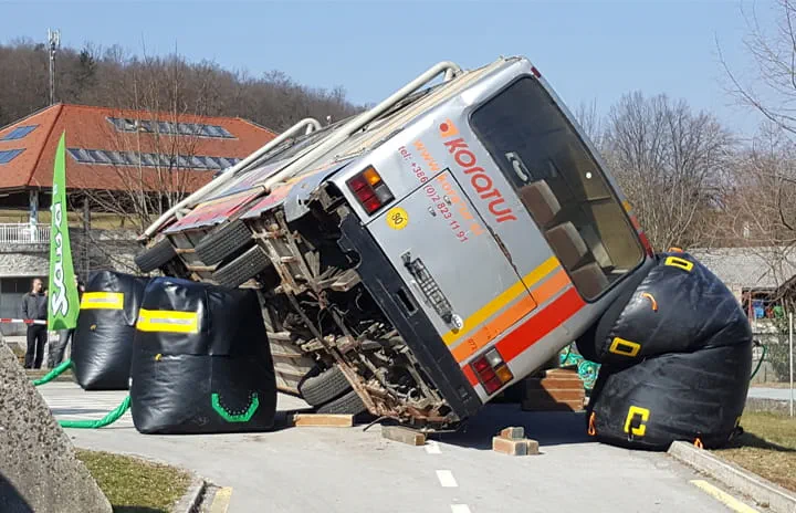 A bus lying in a large catch bag, used for rescue purposes