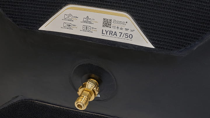 Close-up of the Lyra lifting bag valve connection with visible product label “LYRA 7/50” and technical icons on the textured black surface