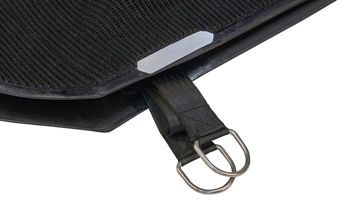 Close-up of the Lyra lifting bag corner showing a reinforced strap with twin metal D-rings and textured black surface.