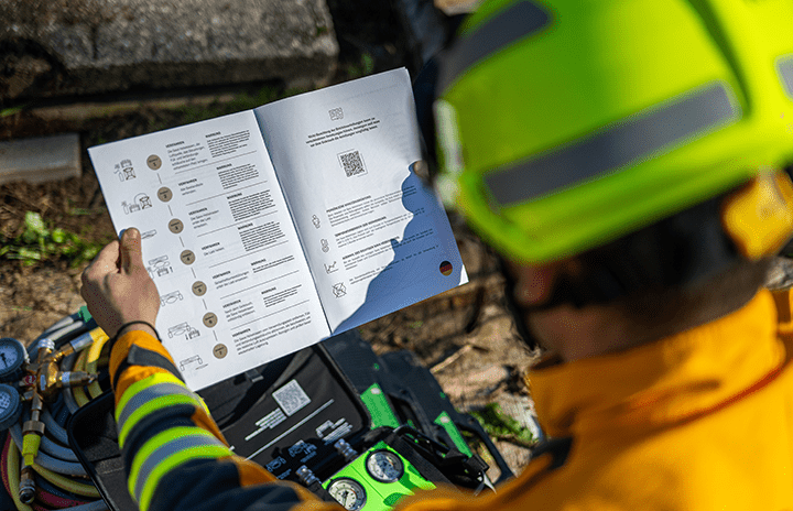 A firefighter in uniform reading a manual of use