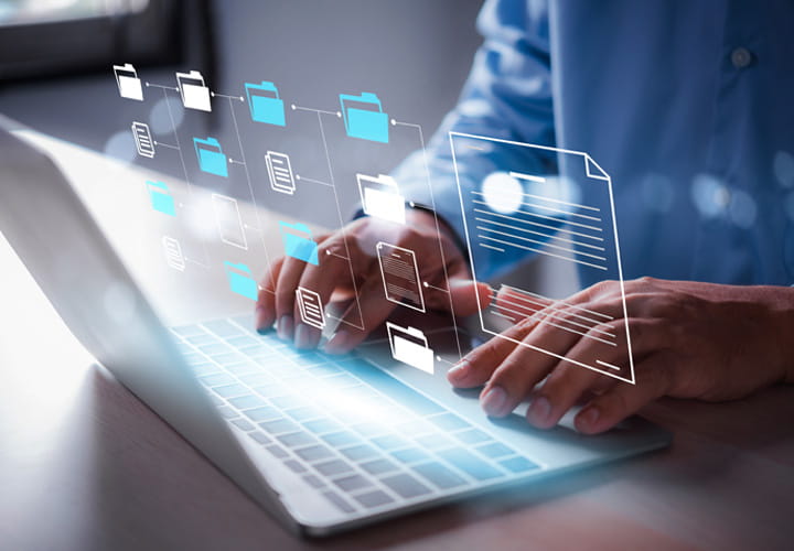 Person using a laptop with digital file and folder icons representing online access to the standard product catalogue for sealing profiles