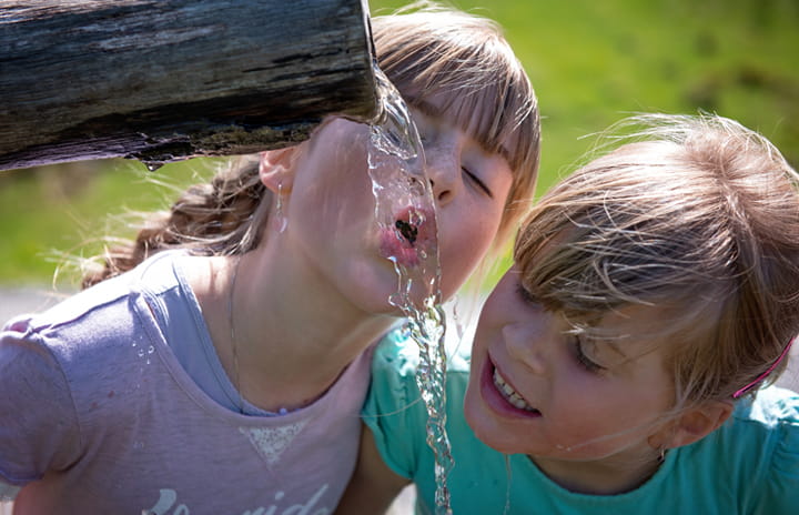 Children drinking water from a fountain